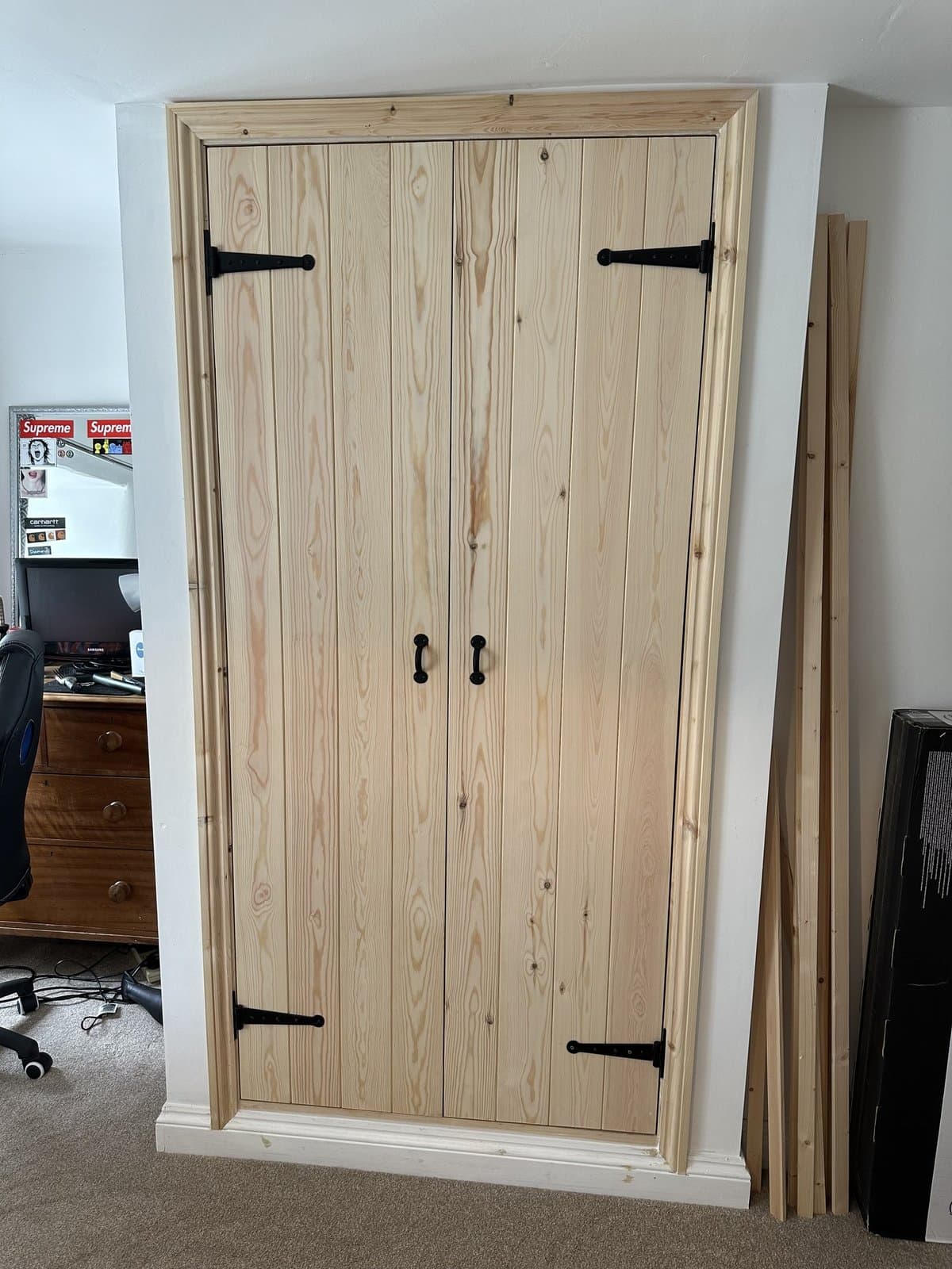 Bespoke pine cupboard doors with black T-hinges and bar handles, hand-built and fitted to a recess