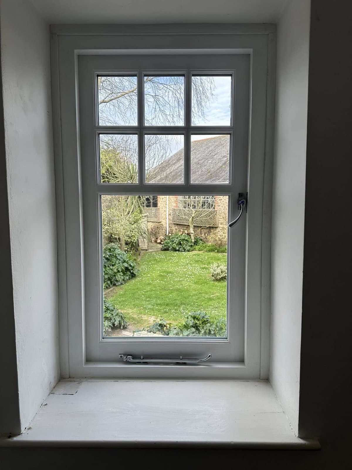 Bespoke timber casement window in a Devon cottage looking out onto the garden — heritage joinery by K.Davey.