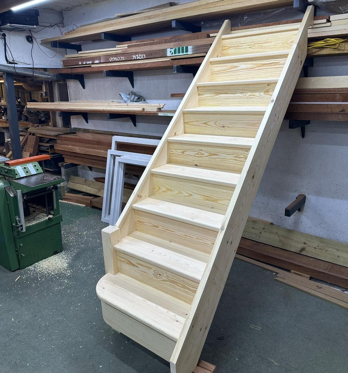 Hand-built pine staircase newly finished and standing in our joinery workshop.