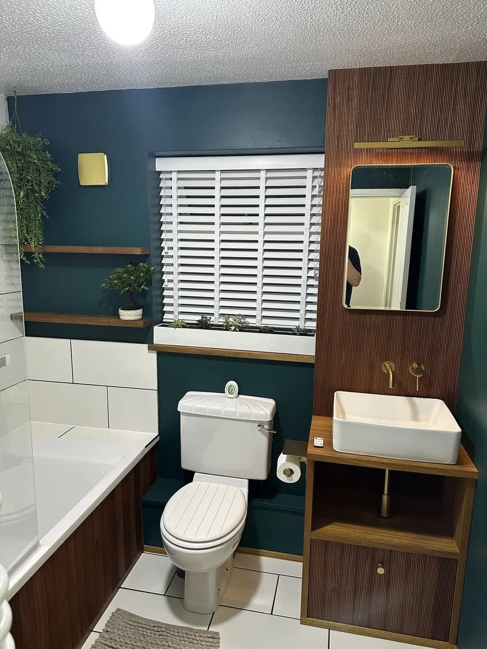 Bespoke timber vanity, shutters and shelving in a finished bathroom with deep teal walls